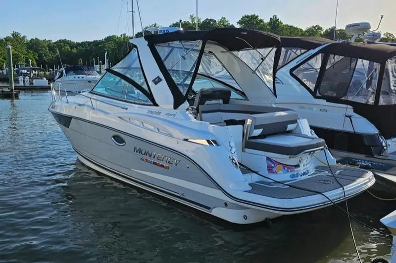 Slide: The Image of 2022 Monterey 295 Sport Yacht interior with sleek seating and modern dashboard at marina. - 11