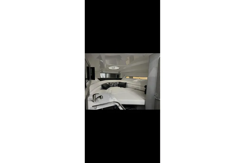 Slide: The Image of 2022 Monterey 295 Sport Yacht interior with sleek seating and modern dashboard at marina. - 14