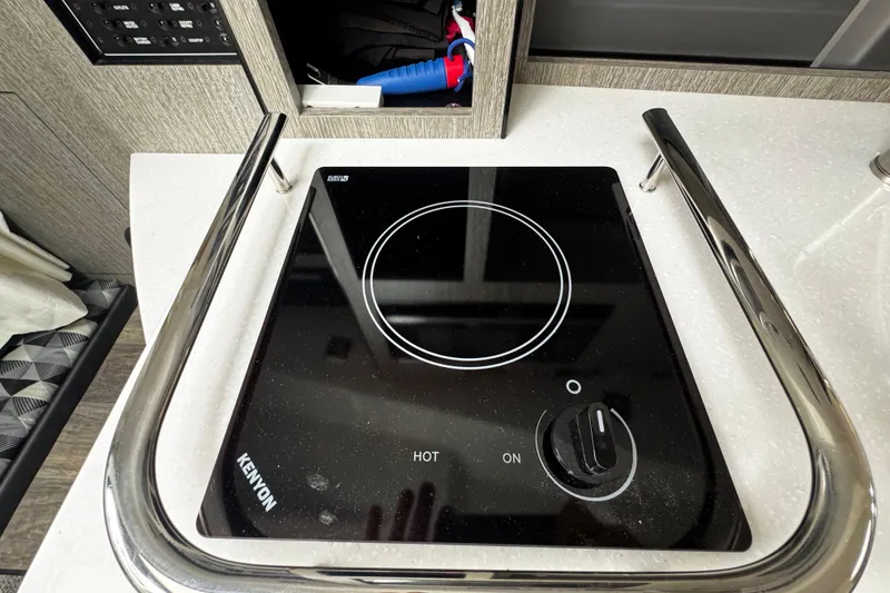 Slide: The Image of Electric stove on 2022 Monterey 295 Sport Yacht, featuring sleek black glass surface. - 34