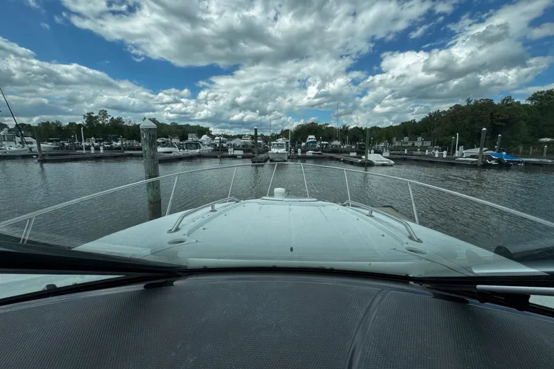 Slide: The Image of View from a 2022 Monterey 295 Sport Yacht approaching a marina under a partly cloudy sky. - 37