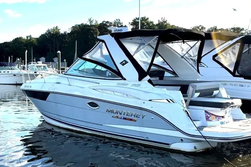 Slide: The Image of 2022 Monterey 295SS Super Sport boat docked in a marina, featuring sleek design and canopy. - 9