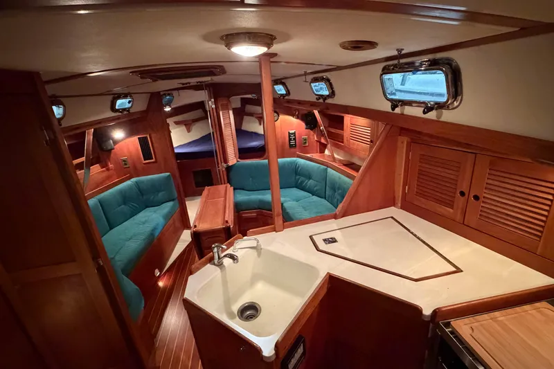 The Image of Interior of a 2000 Tartan 3500 sailboat with cozy seating and wooden cabinetry. - 1