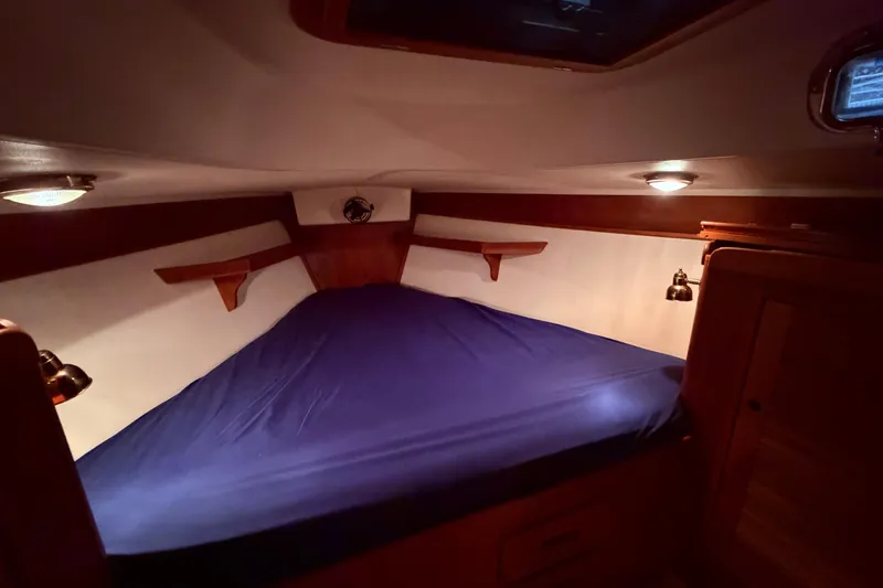 Slide: The Image of Cozy cabin interior of a 2000 Tartan 3500 sailboat with blue bedding. - 10