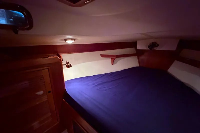 Slide: The Image of Cozy cabin interior of 2000 Tartan 3500 sailboat with blue bedding. - 11