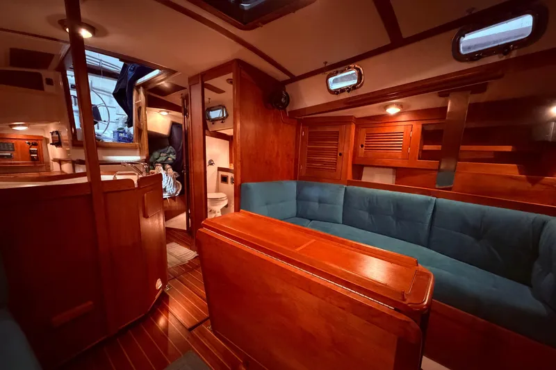 Slide: The Image of Interior of a 2000 Tartan 3500 sailboat with wooden furnishings and blue seating. - 13