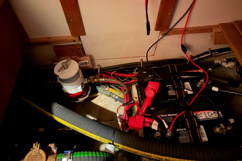 Slide: The Image of Electrical system and components inside a 2000 Tartan 3500 boat, featuring batteries and wiring. - 18