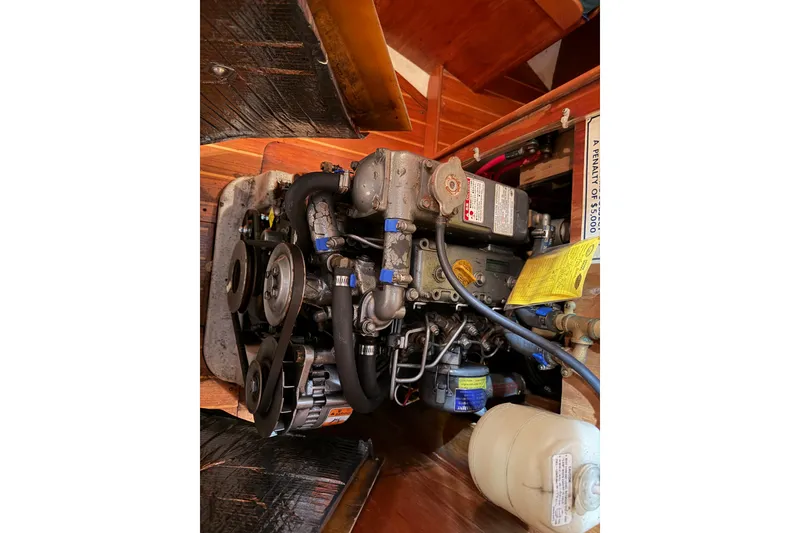 Slide: The Image of Engine of a 2000 Tartan 3500 sailboat, showcasing mechanical components and hoses. - 21