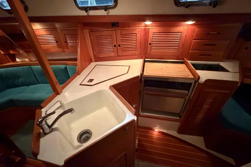 Slide: The Image of Cozy Tartan 3500 yacht interior with wooden cabinetry and compact kitchen area, year 2000 model. - 3
