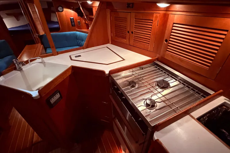 Slide: The Image of Cozy Tartan 3500 yacht kitchen with stove, sink, and wooden cabinetry, year 2000 model. - 7