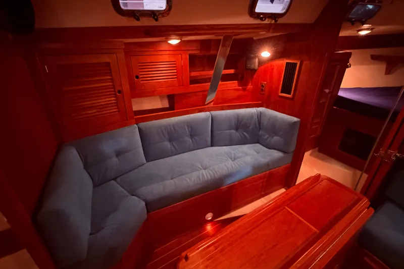 Slide: The Image of Luxurious Tartan 3500 yacht interior with blue cushioned seating, wooden cabinetry, and ambient lighting. - 9