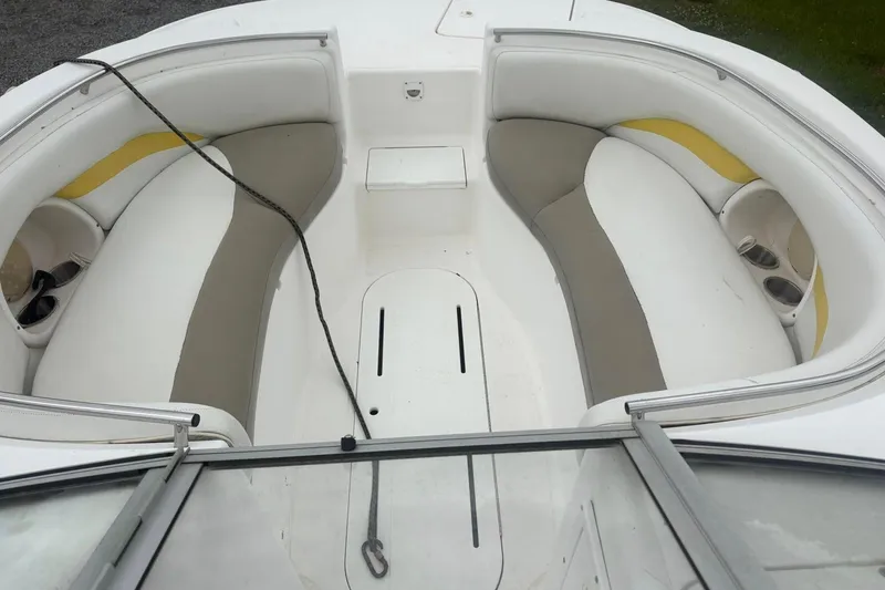 Slide: The Image of 2004 Mariah DX213 boat interior with white and beige seating, cup holders, and rope. - 6
