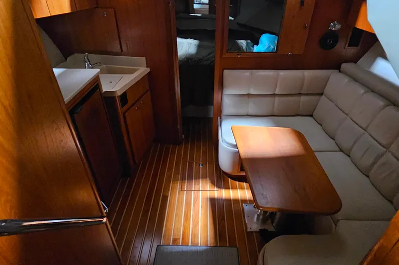 Slide: The Image of Interior of 2000 Tiara Yachts 3500 Open with wood flooring and cozy seating area. - 12