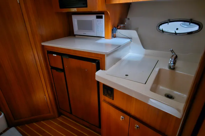 Slide: The Image of Compact kitchen area in a 2000 Tiara Yachts 3500 Open, featuring a microwave and sink. - 13
