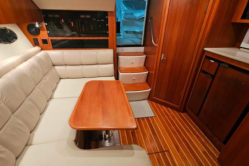 Slide: The Image of Interior of 2000 Tiara Yachts 3500 Open, featuring wood finishes and plush seating. - 24