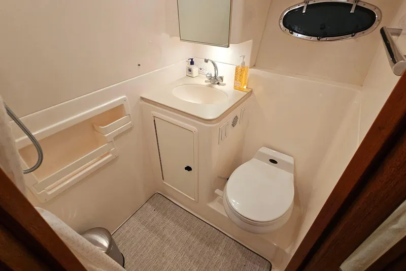 Slide: The Image of Bathroom interior of 2000 Tiara Yachts 3500 Open with sink, toilet, and mirror. - 26