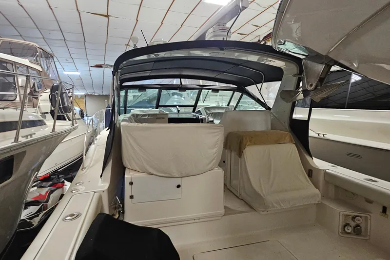 Slide: The Image of 2000 Tiara Yachts 3500 Open in storage, covered seating, indoor marina setting. - 3
