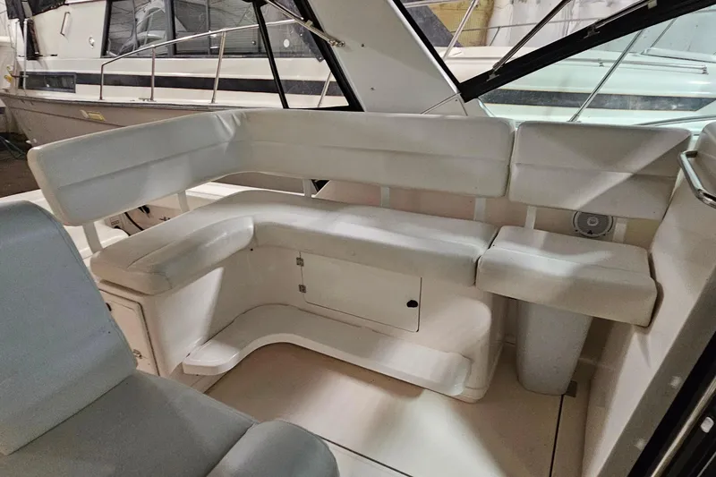 Slide: The Image of Interior seating area of a 2000 Tiara Yachts 3500 Open, featuring white cushioned benches. - 7
