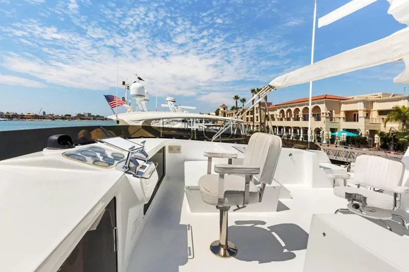 Slide: The Image of 1983 Elliott Yacht Fisher with seating, docked near waterfront buildings under a blue sky. - 15