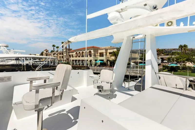 Slide: The Image of 1983 Elliott Yacht Fisher with seating area, docked near waterfront buildings under a clear sky. - 16