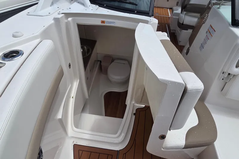 Slide: The Image of 2023 Robalo R317 Dual Console boat interior with compact bathroom and seating area. - 41