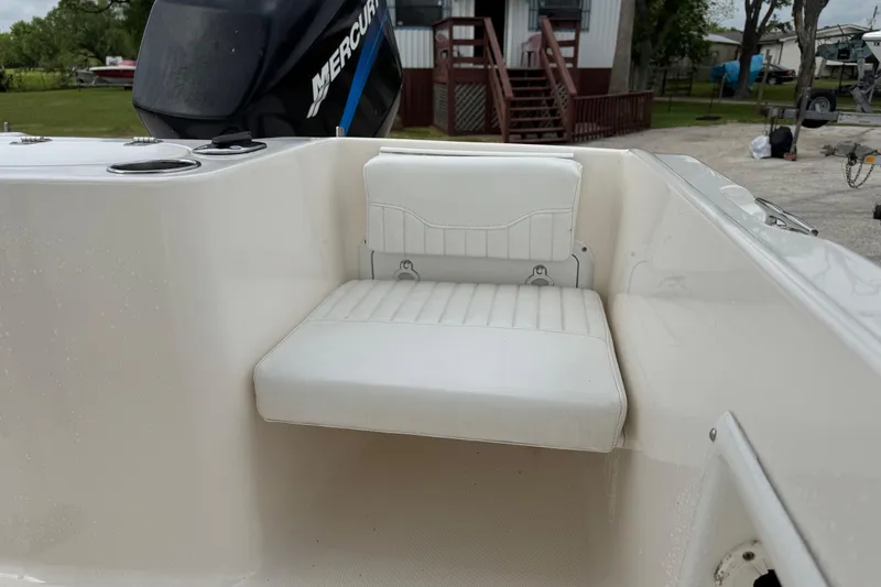 Slide: The Image of 2004 Sea Hunt Triton 186 boat interior with white seating and Mercury engine. - 10