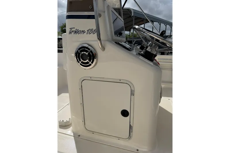 Slide: The Image of 2004 Sea Hunt Triton 186 boat console with steering wheel and speaker. - 11