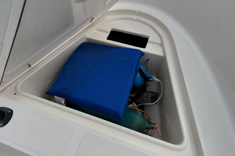 Slide: The Image of Storage compartment of a 2004 Sea Hunt Triton 186 boat with blue cushion and equipment. - 18