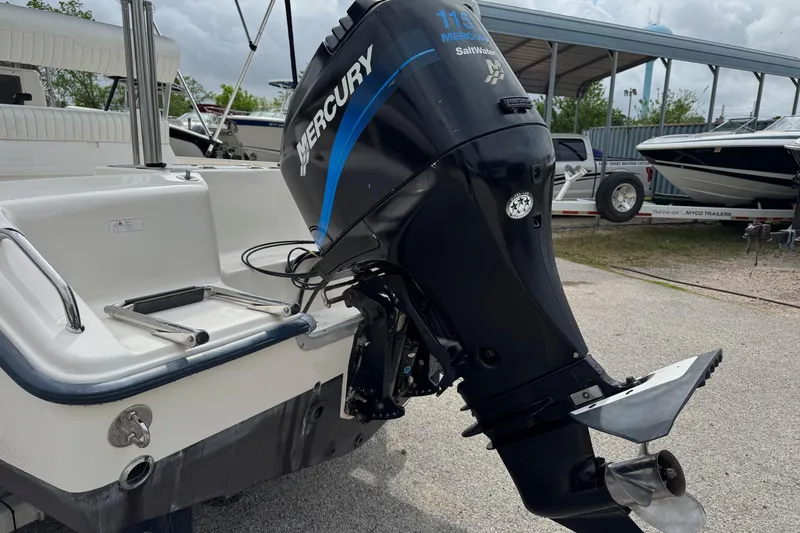 Slide: The Image of 2004 Sea Hunt Triton 186 with Mercury outboard motor in a boatyard setting. - 5