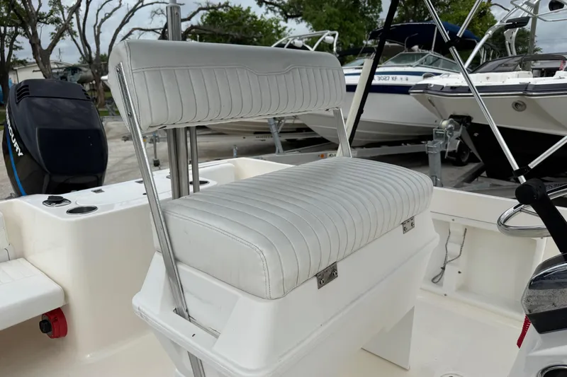 Slide: The Image of 2004 Sea Hunt Triton 186 boat interior with white cushioned seating and Mercury outboard motor. - 7
