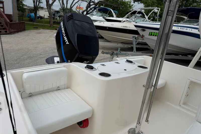 Slide: The Image of 2004 Sea Hunt Triton 186 boat with Mercury engine, white seating, and cup holders. - 8