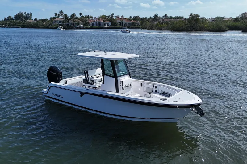 Slide: The Image of 2025 Blackfin 252 CC boat on calm water, showcasing sleek design and modern features. - 2