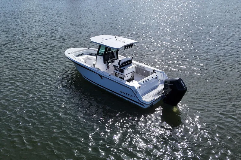 Slide: The Image of 2025 Blackfin 252 CC boat on sparkling water, showcasing sleek design and powerful engine. - 23