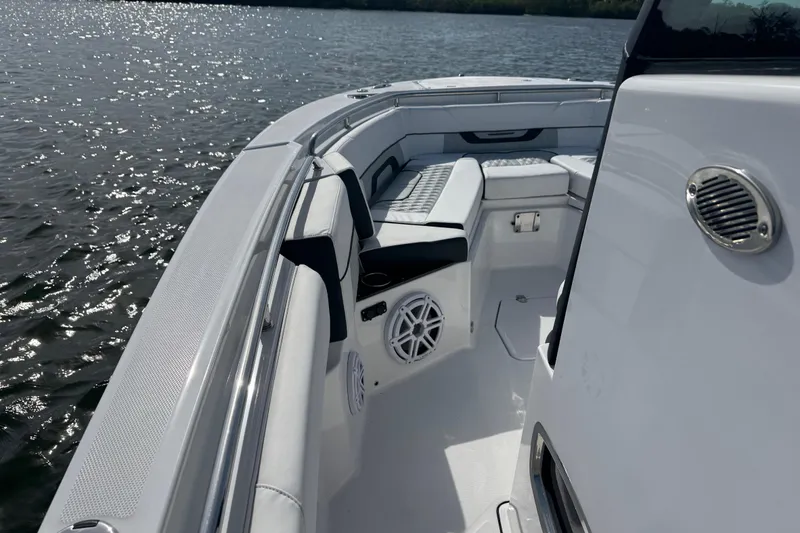 Slide: The Image of 2025 Blackfin 252 CC boat interior with seating and speaker, on calm water. - 25