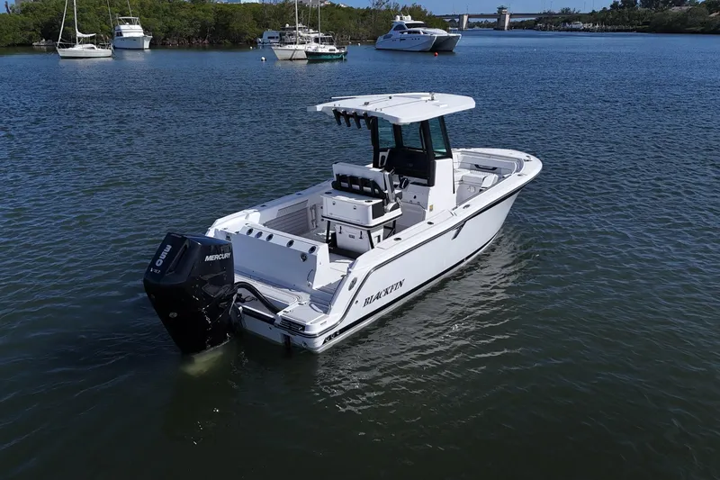 Slide: The Image of 2025 Blackfin 252 CC boat on calm water, featuring a Mercury outboard engine. - 29