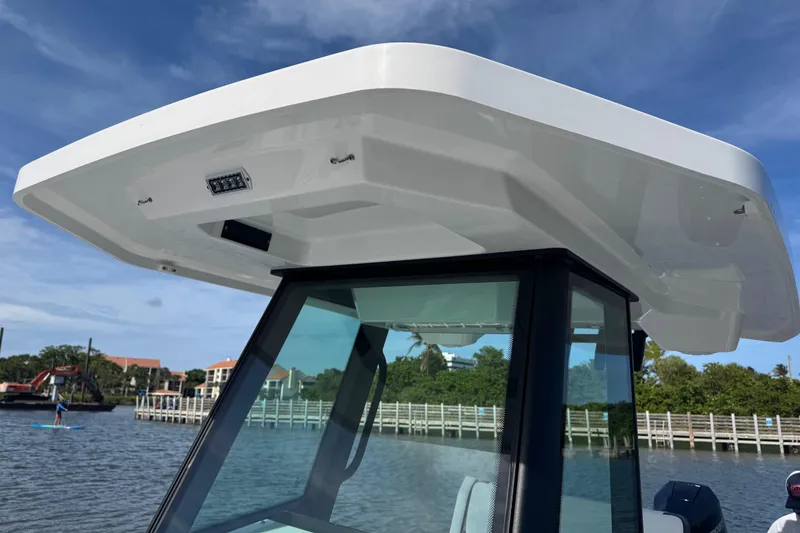 Slide: The Image of 2025 Blackfin 252 CC boat with sleek hardtop design on a sunny day. - 30