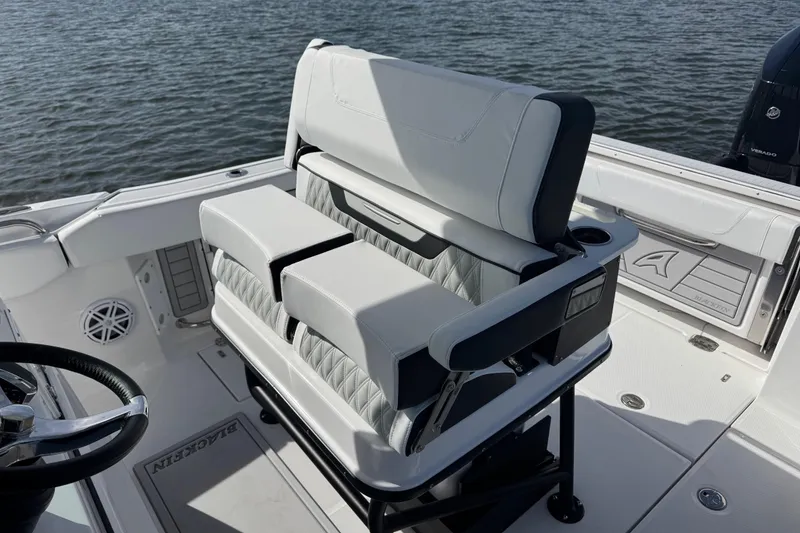 Slide: The Image of 2025 Blackfin 252 CC boat interior with luxurious seating and steering wheel, on calm water. - 34