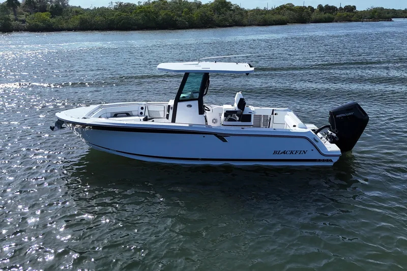 Slide: The Image of 2025 Blackfin 252 CC boat on calm water, showcasing sleek design and powerful engine. - 35
