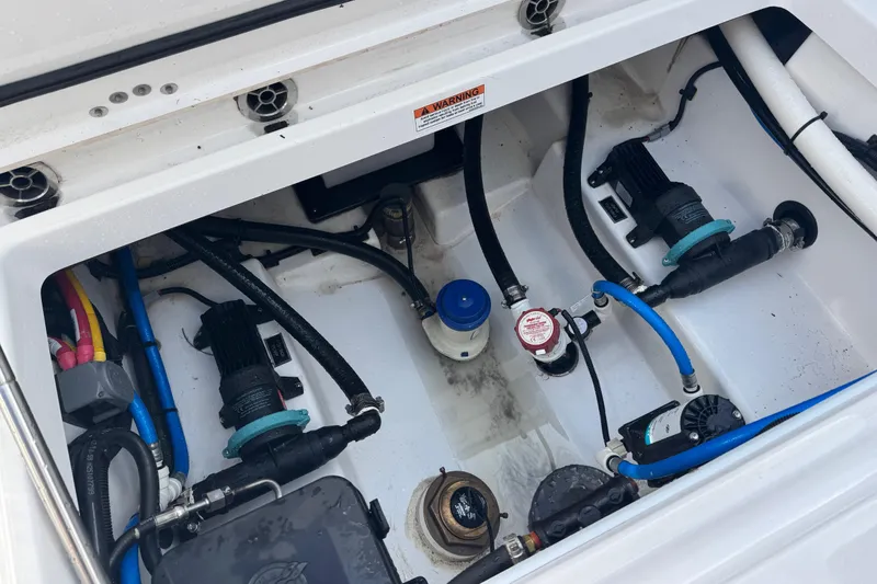 Slide: The Image of Engine compartment of a 2025 Blackfin 252 CC boat, showcasing pumps and wiring. - 40