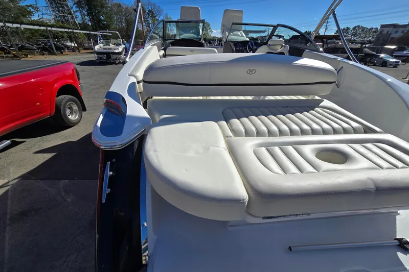 Slide: The Image of 2016 Cobalt R3 boat with white leather seating, parked near a red vehicle. - 28