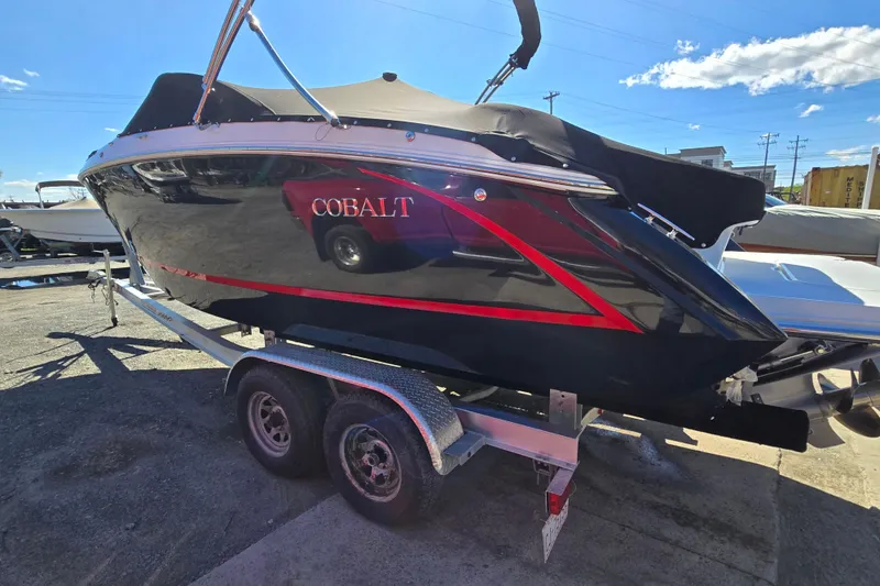 Slide: The Image of 2016 Cobalt R3 boat on trailer, black with red accents, parked outdoors. - 3