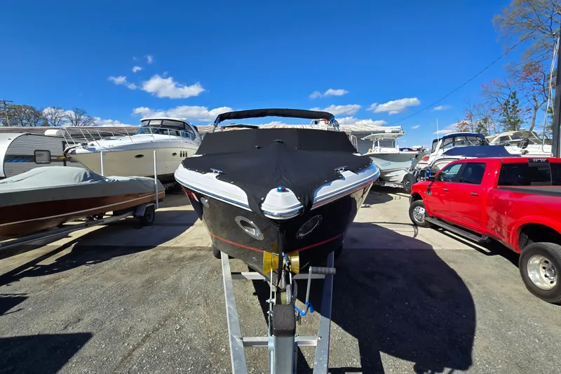 Slide: The Image of 2016 Cobalt R3 boat covered and parked, surrounded by other boats and a red truck. - 6
