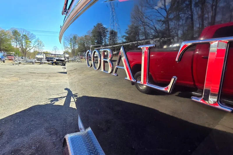 Slide: The Image of 2016 Cobalt R3 boat with reflective surface, parked outdoors near trailers. - 7