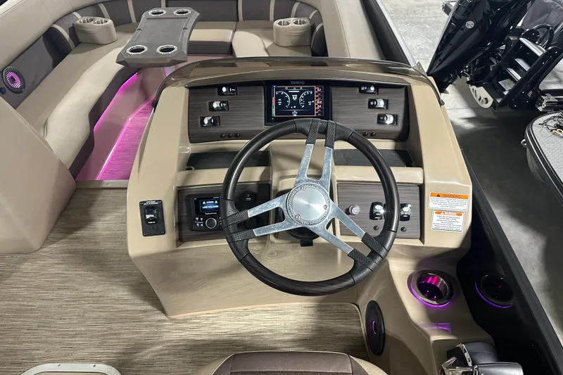 Slide: The Image of 2023 Bennington 25LTSB boat interior with modern steering console and ambient lighting. - 8