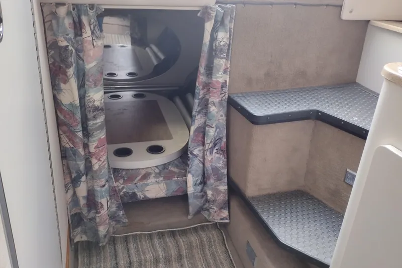 Slide: The Image of Interior cabin of a 1996 Crownline 250 CR boat with patterned curtains and carpeted steps. - 15