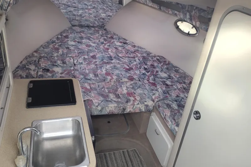 Slide: The Image of 1996 Crownline 250 CR cabin interior with kitchenette and patterned upholstery. - 19