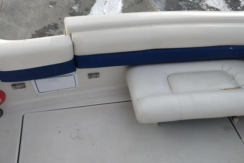 Slide: The Image of 1996 Crownline 250 CR boat interior with white and blue seating, showing wear. - 23