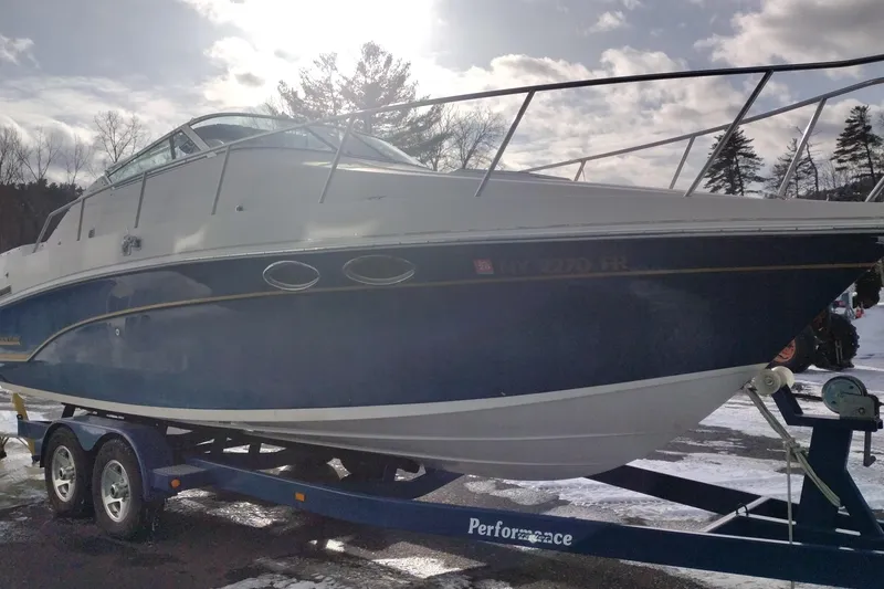 Slide: The Image of 1996 Crownline 250 CR boat on trailer, parked outdoors under cloudy sky. - 4