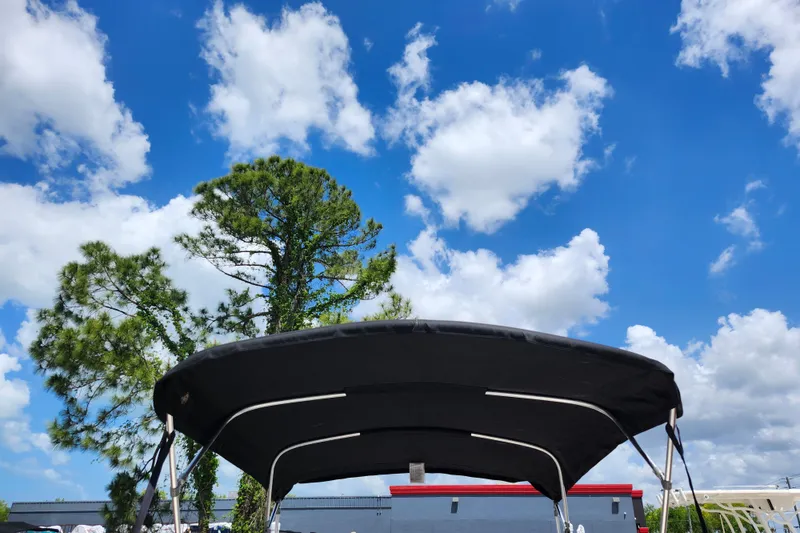 Slide: The Image of 2022 Carolina Skiff 178 JLS boat canopy under blue sky with clouds. - 10