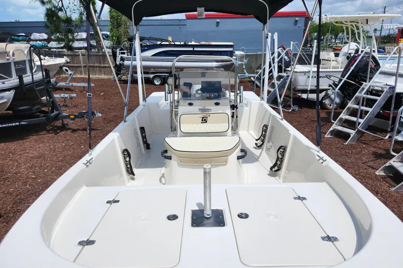Slide: The Image of 2022 Carolina Skiff 178 JLS boat interior with seating and console, displayed outdoors. - 15