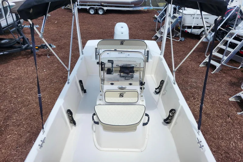 Slide: The Image of 2022 Carolina Skiff 178 JLS boat interior with seating and console, displayed outdoors. - 17